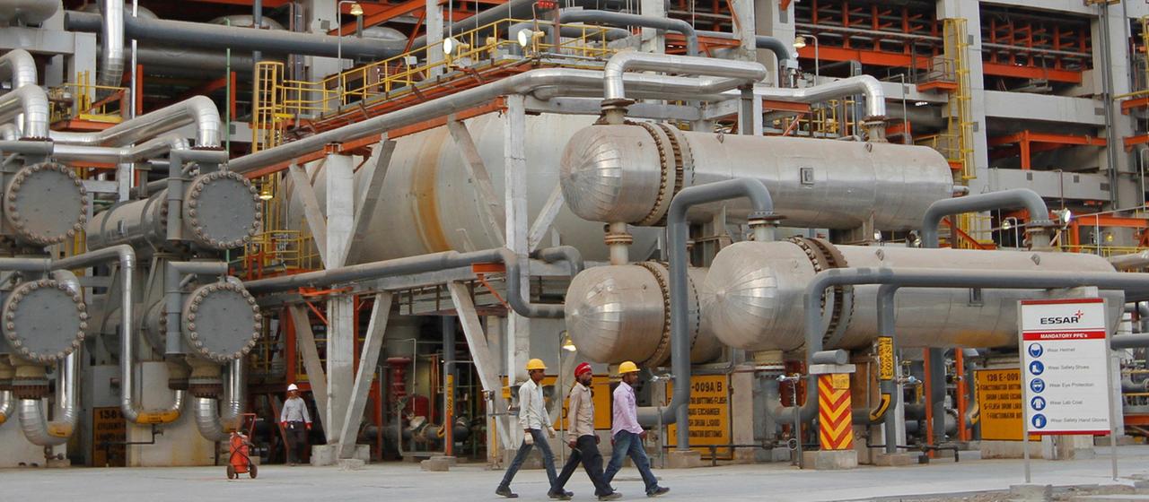 Mitarbeiter gehen an Rohren in der Vadinar Raffinerie in Indien vorbei (Archivbild von 2012).