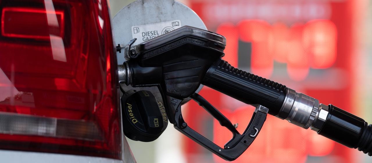 Ein Zapfhahn für Diesel steckt in einem Auto.