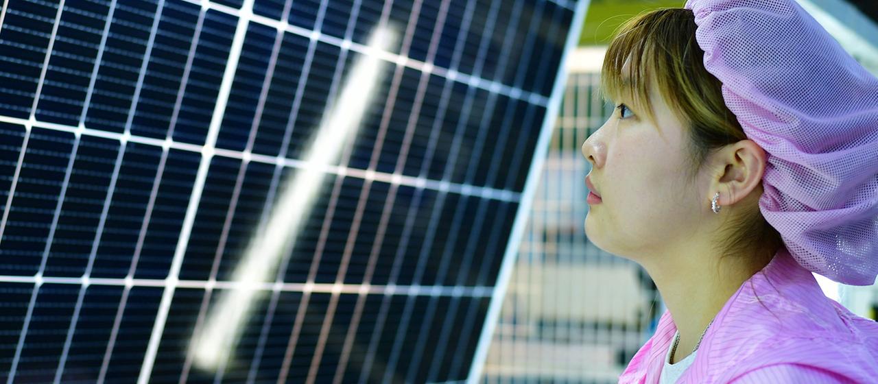 Ein Arbeiterin bei der Qualitätsprüfung an Photovoltaikmodulen, Nantong, China.