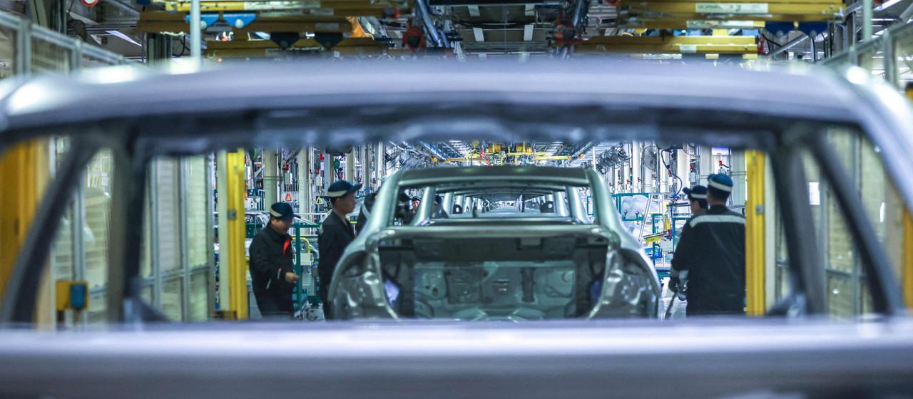 Mitarbeiter montieren an einem Fließband in einem Geely-Werk in Shenyang Methanol-Plug-in-Hybrid-Limousinen.